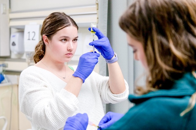 Nursing students Ashley Jensen, left, and Courtney Houtz practice injection procedures in the clinical skills lab at University of San Francisco in San Francisco, Calif. on Oct. 9, 2023. Health care is one of the areas that has added jobs since 2022. Credit: Photo by Amir Aziz for CalMatters