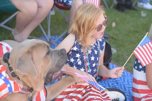 Corona resident Delilah Feher watches the 4th of July parade on Main Street with the family dog, "Diesel."