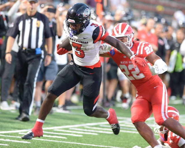 Corona Centennial running back Malachi Ruby tries to get by Mater Dei's Ace Lautele in the first quarter of non-league game Thursday in Santa Ana.