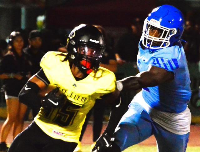 Cajon’s Brandon Rivers (15) escapes the grasp of Norco defender Kameron Brown (2) during the Cowboys 29 – 7 victory over the Cougars in the opening game of the 2024 football season. Credit: Photo by Gary Evans