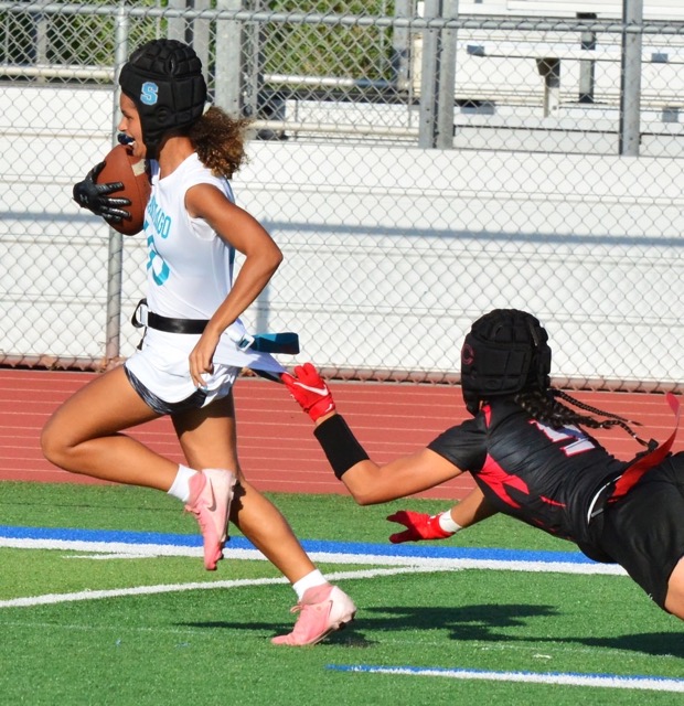 Corona Santiago’s Talan Beyer (left) escapes the grasp of a Centennial defender who grabs the shirt but not the flag as Beyers scores the game-winning touchdown.  The Sharks topped the Huskies 12 – 6.
Credit: Photo by Gary Evans
