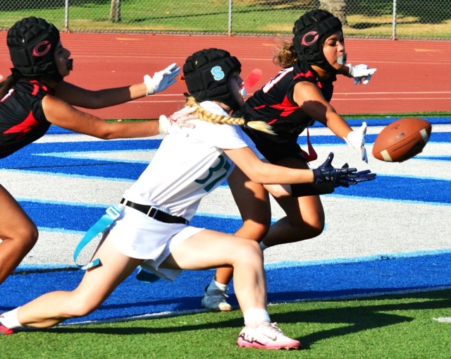 Corona Santiago’s Gracie Weinrick (center) is about to catch an extra point attempt while Centennial’s Giselle Maldanado (left) and Brystal Albright (right) defend.  Weinrick fell at the one yard line.  
Credit: Photo by Gary Evans
