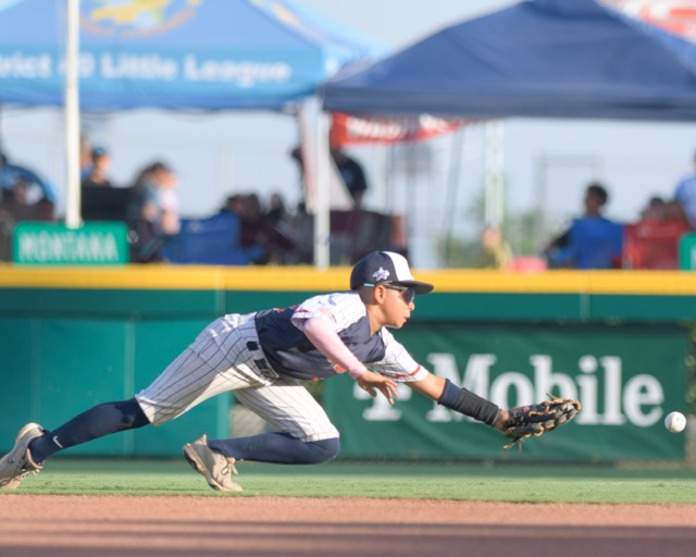 Eastvale Little League. Eastvale second basemen Carson Tatum makes a futile dive for a ground ball into right field .