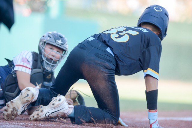 Eastvale catcher Grady Gentner watches as Maui East Central's Evan Tavares scores.