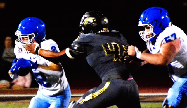 Citrus Valley’s Ismael Gonzalez (center) grabs Trevor Schneider of Norco’s face mask, while Gonzalez appears to be held from behind by the Cougar’s Shawn Holtz (right). A face mask penalty was called, but not a hold. The Cougars held on to defeat the Blackhawks 17 – 10. The 2-3 Cougars begin league play at Murrieta Valley on Friday, October 3. Credit: Photo by Gary Evans