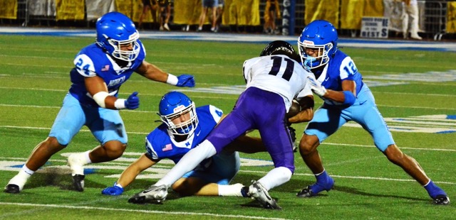 Featured Photos 9-13-24. Norco’s Maddox Barrios (24), Cole Rodgers (center), and Johnny Salazar (12, right) surround and tackle Rancho Cucamonga’s Cameron Sermons (11) after a pass reception for a short gain.