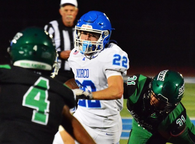 Norco’s Trevor Schneider (22) eyes Upland’s Osric Randolph (4) while evading Cole Brodie (31) during the Highlanders 34 – 17 victory over the Cougars.
Credit: Photo by Gary Evans
