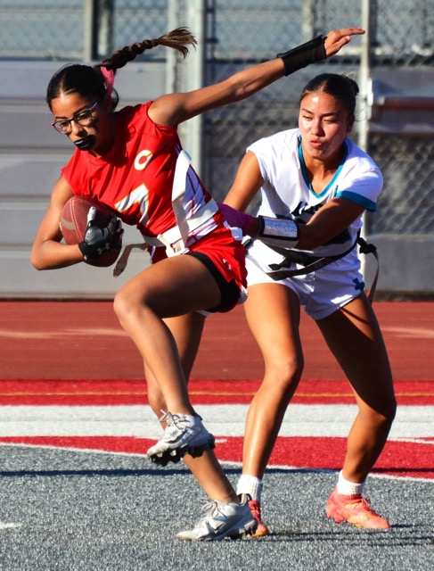 Corona receiver Sienna Romero (7) works to escape an Aliso Niguel defender after catching a pass.