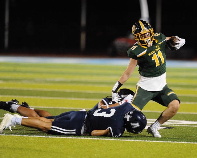 Notre Dame’s Gael Bogarin is brought down by San Bernardino Aquinas tacklers in the first half of the game at Riverside Ramona last Thursday. The visiting Falcons shut out the Titans, 48-0. Credit: Photo by Jerry Soifer