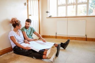 ADU (Seated Couple with Plans) Credit:: (c) monkeybusinessimages / iStock via Getty Images Plus