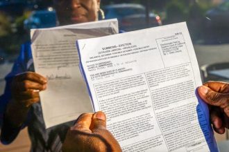 Nancy Wiles holds her eviction notice on Dec. 4, 2023.  Credit: Photo by Manuel Orbegozo for CalMatters