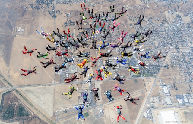 Ranging in age from 18 to 70, the record breaking jumpers had to completely separate from each other before forming the second different snowflake pattern Credit: Photo by Kristian Caulder