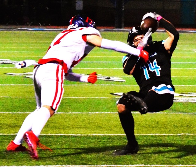 Riverside King defender Logan George (7) knocks down Santiago receiver Ryan Wilson (14) who hung on to the pass from quarterback Clayton Plew during the first quarter of the Wolves 35 – 20 victory over the Sharks. Credit: Photo by Gary Evans