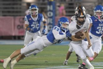 Norco's Cole Rodgers makes a diving tackle on Roosevelt's Matthew Ochoa at Norco Friday. Credit: Photo by Jerry Soifer