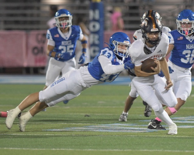 Norco's Cole Rodgers makes a diving tackle on Roosevelt's Matthew Ochoa at Norco Friday. Credit: Photo by Jerry Soifer