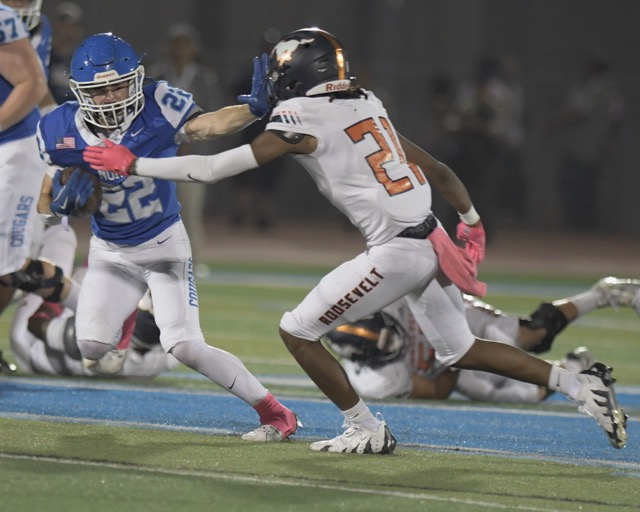 Norco running back Trevor Schneider stiff-arms Roosevelt's Tra'von Flournoy as the Cougars roll to a 49-7 win last Friday. Photo by Jerry Soifer
