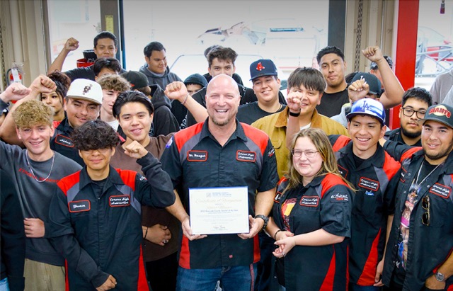 Corona High Automotive Technology Teacher Bob Mauger is surrounded by students celebrating their CA Teacher of the Year. Credit: Riverside County Office of Education