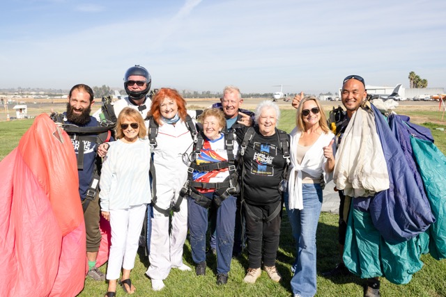 The team gathers after their jump out of the jet!
From left to right:
Raffi Tokhalyan (Nancy Gruttman-Tyler’s Tandem Instructor), Diane Conatser (Founder of Skydive Perris and owner of the DC-9 jet), Scott Smith (Kim Emmons Knor’s TI), Nancy Gruttman-Tyler, Kim Emmons Knor, Jay Stokes (Guinness World Record holder of the most skydiving jumps in 24 hours… 640!), Donna Wardean Dann, Melanie Conatser (co-owner of Skydive Perris) and Lee Kibang (Donna Wardean Dann’s TI)