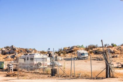 Photo: FirstDistrict Caption: Some residential areas in Riverside County's First District lack paved roads. This trailer is in a community off of an unpaved road in Mead Valley, on October 3, 2024.  Credit: Photo by Elisa Ferrari for CalMatters