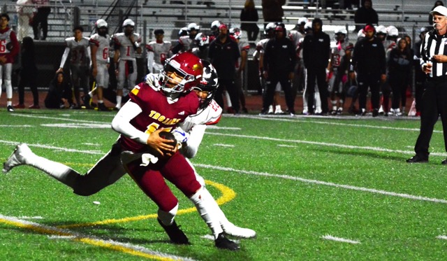 Riverside Hillcrest QB Alexander Villasenor will be in need of chiropractic care after Valley View’s Eligah Buelna (22) first grabbed his facemask and then horse collared Villasenor, who still broke free of the tackle attempt.