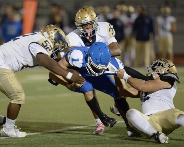 Norco quarterback Joseph Stoffel is gang-tackled by Vista Murrieta defenders Cecil Mortis, Myles Robinson, and Gavin Romero in a Big West Conference game. Credit: Photo by Jerry Soifer