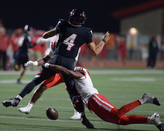 Corona Centennial quarterback Husan Longstreet who recently committed to USC loses the football under attack by Mater Dei defenders Friday in the CIF Div. 1 semifinal game at Centennial. Mater Dei won, 36-7.