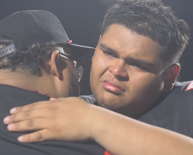 Centennial defensive lineman Josiah Perez is consoled by assistant coach Sean Gueringer Friday after the Huskies fell a game short of the title match. After an 0-2 start Centennial's season ends at 9-3, bookended by two losses to the top-ranked team in the nation.