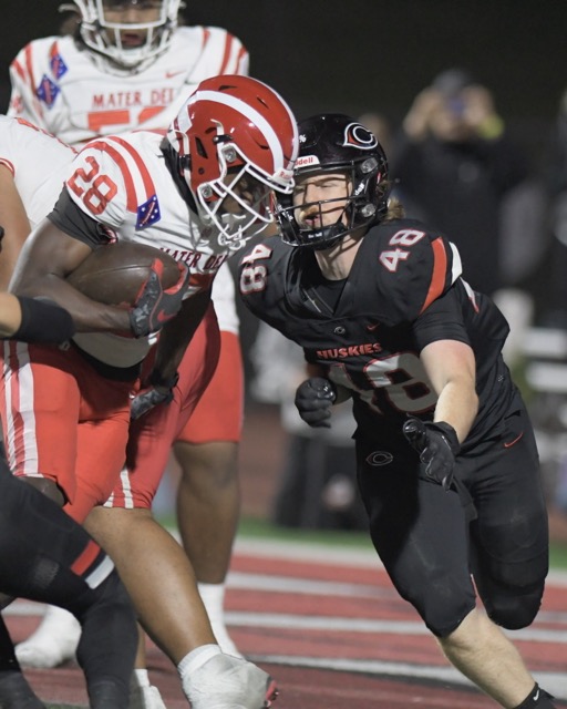 Corona Centennial Huskies. Corona Centennial defender Hayden Zentner comes up to tackle Mater Dei ball carrier Kennie Leggett. 