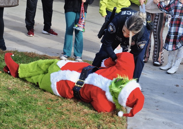 Corona police officer Maria Herrera a “Grinch” Santa at the Kids & Cops Holiday Magic event. Credit: Photo by Jerry Soifer