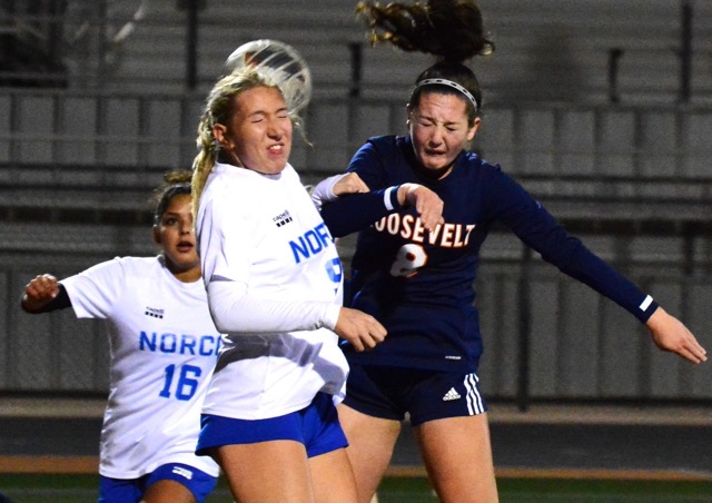 A single frame of action captures the intensity as Norco’s Briana Sousa (9) and Eastvale Roosevelt’s Emma Gause (8) as the corner kick passes over them.