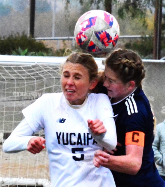 Yucaipa’s Jolee Rutland (5) and Eastvale Roosevelt’s Ireland Churchill (right) fight for the header during the Mustangs 7 – 0 victory over the Thunderbirds in the first game of the Silver Lakes Tournament. Photo by Gary Evans