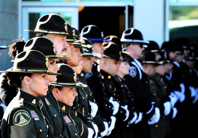 Riverside County Sheriff Deputies and officers from multiple agencies await the arrival of Deputy Timothy Corlew’s casket at Harvest Christian Fellowship in Riverside. 