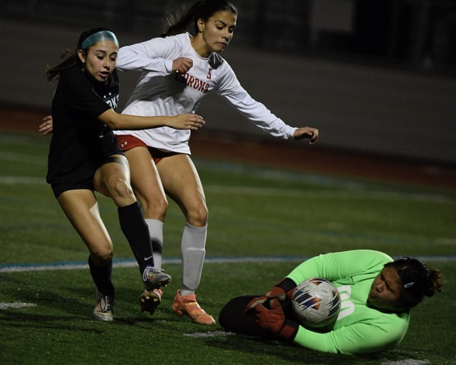 Corona high goalkeeper Brianna Cacao stops a scoring effort by Corona Santiago's Alyssa Fernandez who is defended by Corona's Alannah Noriega. Cacao was under pressure all night Thursday from Santiago in a 9-0 road loss in a Big Viii League game