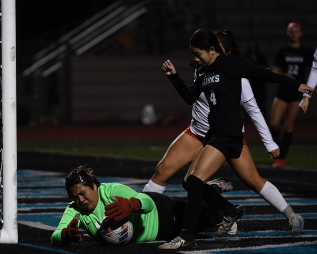 Featured Photos 1-17-25 . Corona goalkeeper Brianna Cacao swarms over the ball, under attack from Santiago's Megan Vo.