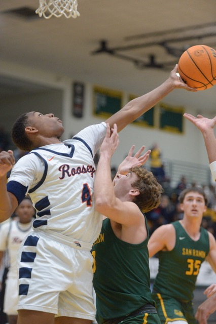 Jackson Higgins, of Eastvale Eleanor Roosevelt High, reaches over San Ramon Valley’s Elliot Conley in a first-round game at The Classic at Damien in La Verne. Roosevelt won 84-63. The Mustangs captured the platinum division title of the prestigious tournament, culminating a 4-win run with a thrilling 56-55 overtime win over previously unbeaten St. John Bosco. Credit: Photo by Jerry Soifer