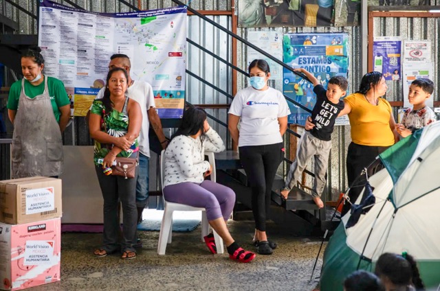 Bianco. Migrants wait to receive toiletry items at Moviemiento Juventud 2000 in Tijuana on July 26, 2023. Photo by Adriana Heldiz, CalMatters