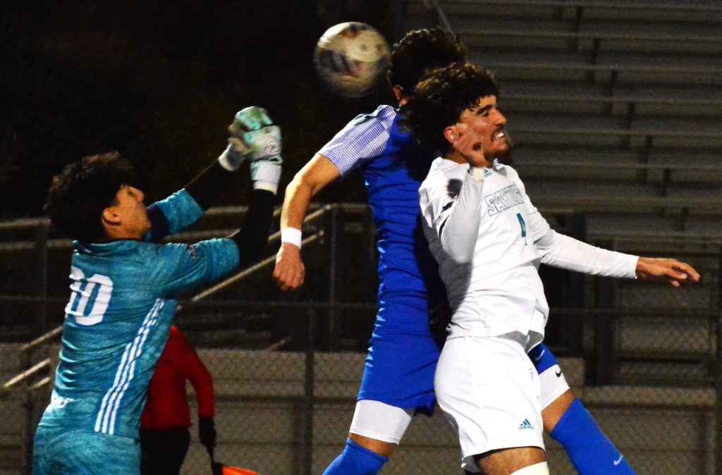 Corona Santiago’s goalie Gabriel Mateos (00) tries to punch the ball away from Norco’s Gabriel Luna (background) while Haalid Shennawi (4) attempts the header. 