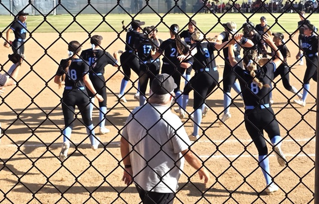 Norco Coach Rick Robinson (center) watches his softball team celebrate the final out as the Cougarsʻ clinched a berth in the CIFSS championship game.
