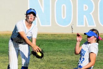Norco centerfielder Dillyn Eckenrod Left) makes a running catch of a low line drive while right fielder Dakota Potter (right) slides in for backup during the Cougars’ 6 – 3 victory over Riverside King.