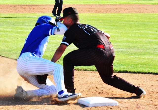 Norco’s Elijah Alvarez (left) appears to be tagged by Corona Centennial third baseman Bobby Anderson a hair before Alvarez’s toe reaches 2nd base. However, the call was “safe,” starting a five-run rally in the bottom of the sixth inning for the Cougars, who defeated the Huskies 9 – 2.   