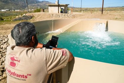 Heli Hydrants - Glenn Chavez sets a timer as water fills a newly installed Heli-Hydrant, a small, open tank that helicopters can rely on to get water faster for urban fires, Friday, April 11, 2025, in Cabazon, Calif. Credit: Brittany Peterson AP Photo