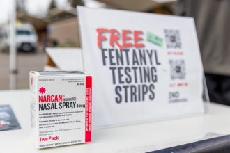 California Gov. Gavin Newsom announced today that the state will sell Naloxone, the overdose-reversal medicine, to any resident at a steep discount. Here, a box of Narcan nasal spray sits at UC Berkeley student organization End Overdose’s table at Sproul Plaza on Jan. 23, 2024.  Credit: Photo by Juliana Yamada for CalMatters