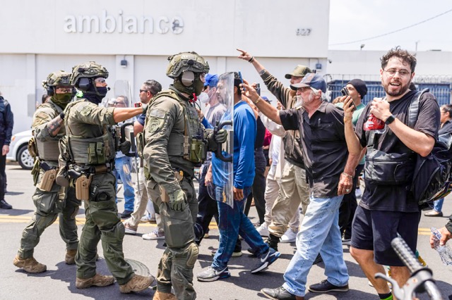Federal immigration authorities face off against protesters during an ICE raid at Ambiance Apparel in Downtown Los Angeles on June 6, 2025. Photo by J.W. Hendricks for CalMatters