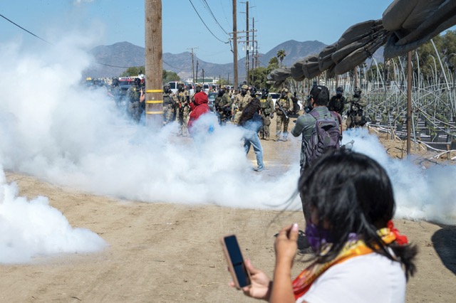 Immigration Raids. Federal immigration agents toss tear gas at protesters during a raid in the agriculture area of Camarillo, Calif., Thursday, July 10, 2025. (AP Photo/Michael Owen Baker)