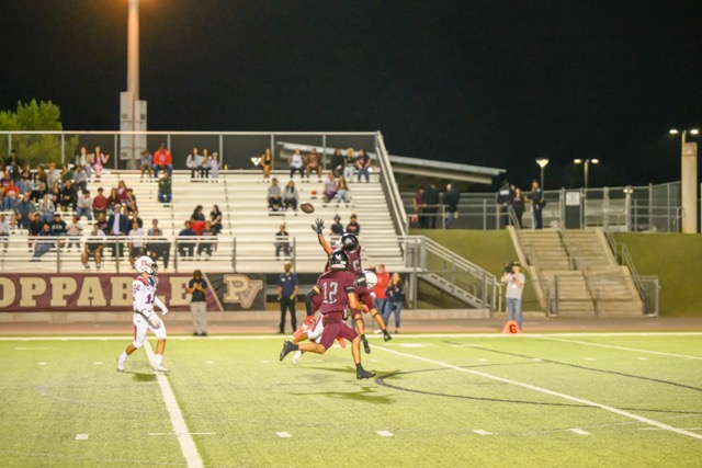 A swarm of Paloma Valley players take to the sky, sandwiching a Heritage wide receiver, for the interception on an overthrown pass.