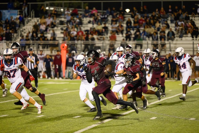 Paloma Valley Wildcats RB, Arthur Clemmons (4) turns the corner for a breakawy run, as Matt Mason (37) and Ayden Rodriguez (26) pursue.