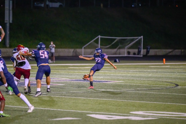 Punter Benjamin Domiguez (22) punts the ball away.