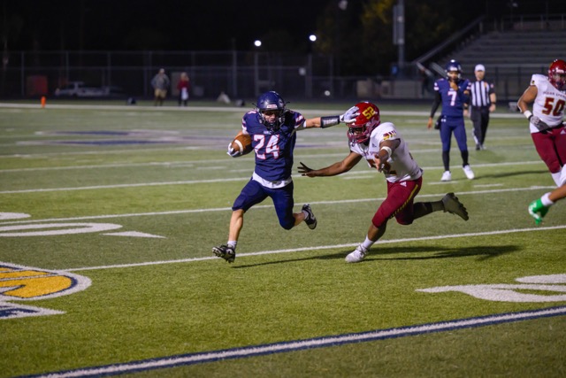 RB Codie Bowie (24) stiff arms a defender to bounce the run outside for a few yards.