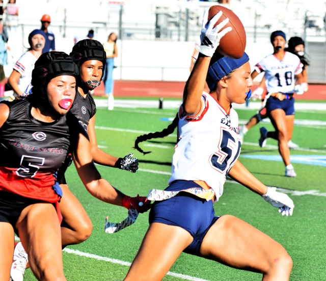 Corona Centennial’s Brystal Albright (5) clutches the flag of Roosevelt’s Lotolelei Sivas (50) during the Mustangs’ 38 – 6 victory over the Huskies.