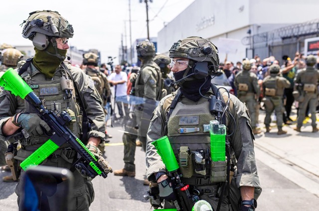 Federal Officers. Masked federal agents encounter protesters during an ICE raid at a garment company in Los Angeles on June 6, 2025. Credit:  Photo by J.W. Hendricks for CalMatters